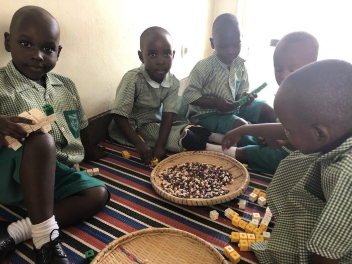 Young students playing with blocks and beans.