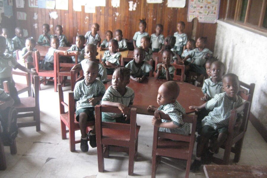 classroom of children in Liberia sitting around tables