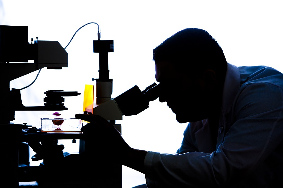 UNMC scientist using a microscope.