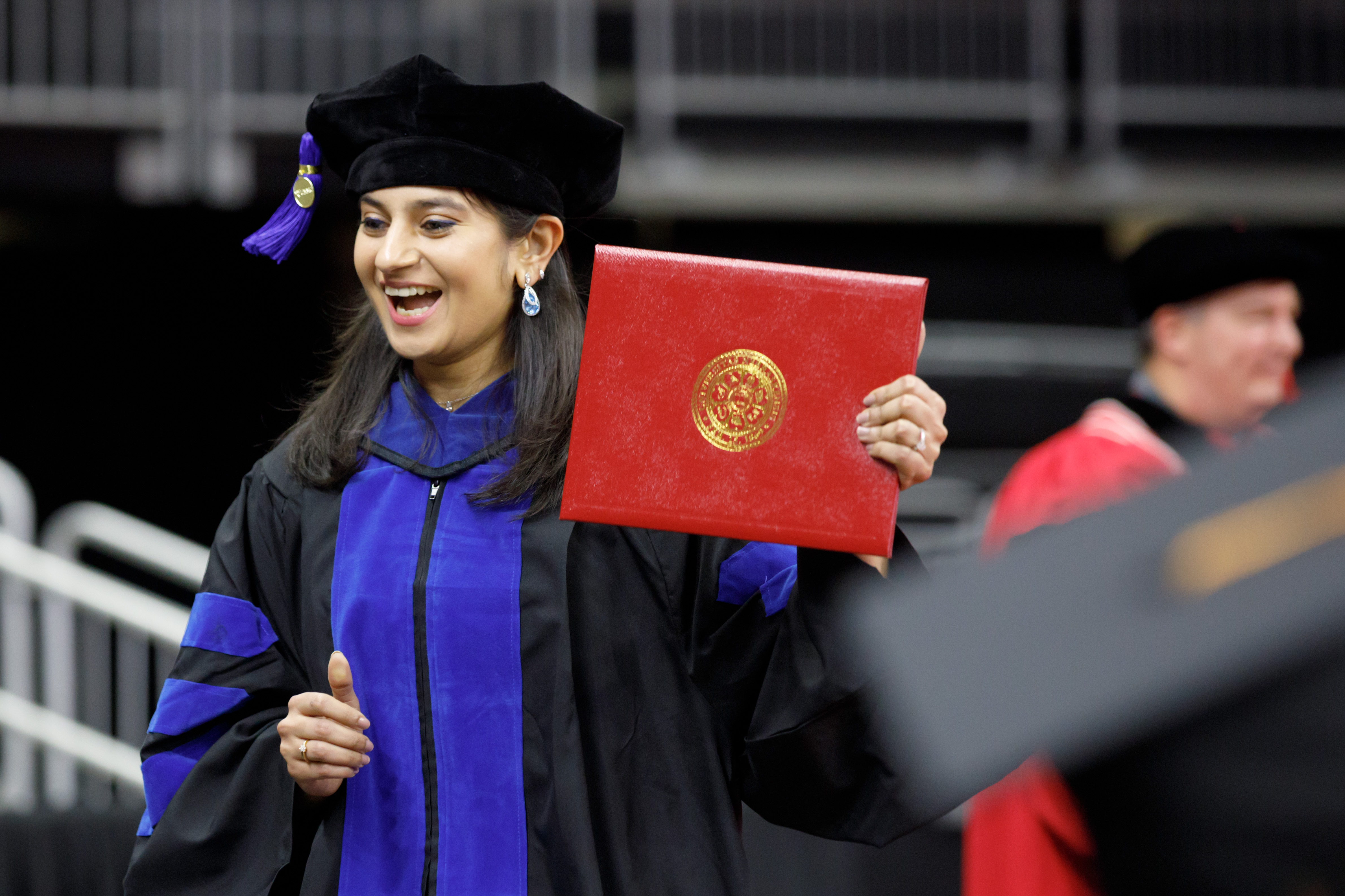 woman in cap and gown holding a diploma